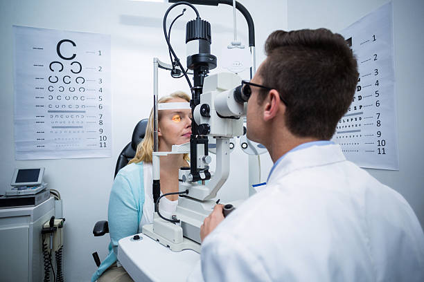 istock Optometrist examining female patient on slit lamp 636221830