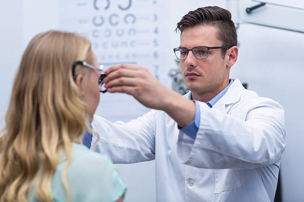 Optometrist examining female patient with phoropter Optometrist examining female patient with phoropter Optometrist examining female patient with phoropter Messbrille stock pictures, royalty-free photos & images