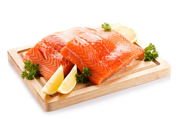 Fresh raw salmon fillet on cutting board on white background stock photo