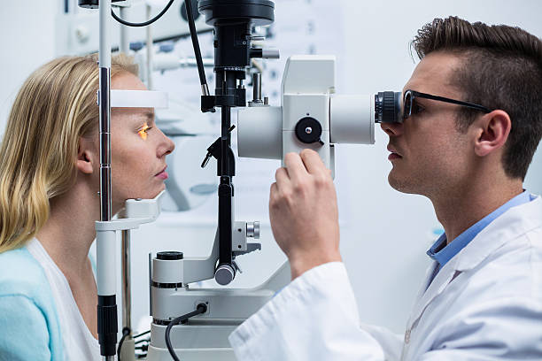 istock Optometrist examining female patient on slit lamp 636223468