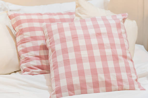 istock baby pink plaid pillow on white mattress 636228110