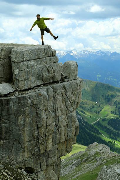 istock Male hiker is joking on the precipice edge, Latemar 636228344