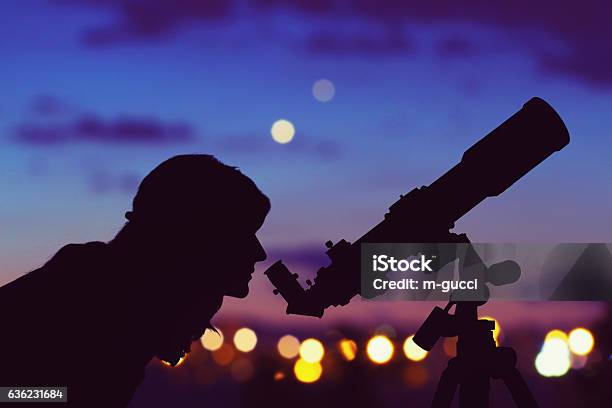 Girl Looking At The Stars With Telescope Beside Her Stock Photo - Download Image Now