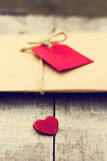 istock Gift in kraft paper with red card and heart 636232310