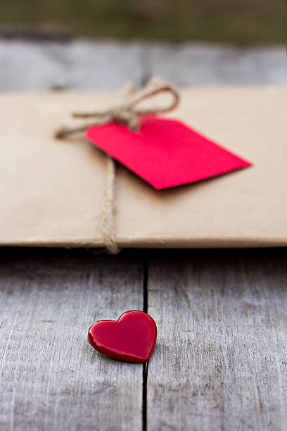 istock Gift in kraft paper with red card and heart 636232424