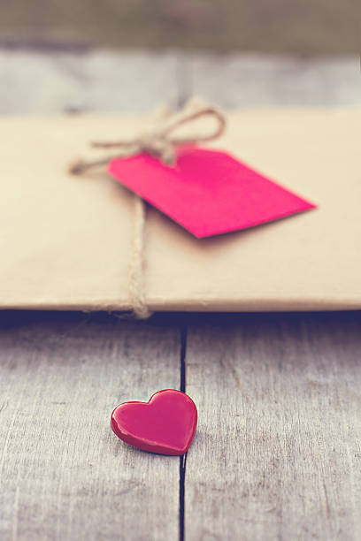 istock Gift in kraft paper with red card and heart 636233096