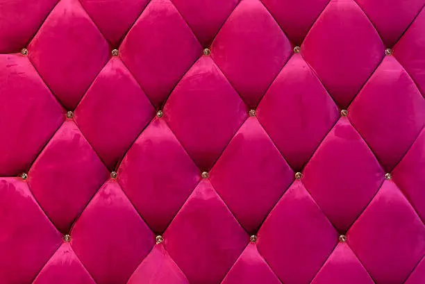 Photo of background of shocking pink velvet sofa with crystal botton