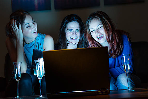 istock Three girlfriends, drinking champagne, watchng something interes 636234350