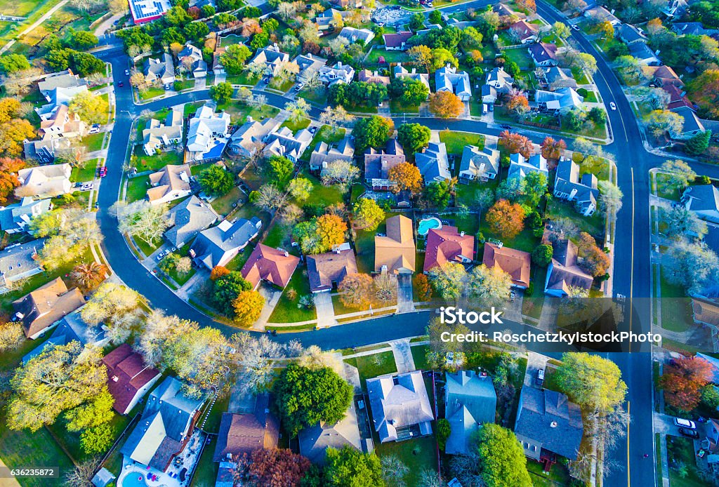 Colorful Fall Aerial Homes in Modern Suburb Colorful Fall Aerial Homes in Modern Suburb outside of Austin , Texas in Round Rock, TX. Curved streets , fall leaves and colorful trees , with colorful roofstops. Aerial drone shot looking down.  Aerial View Stock Photo