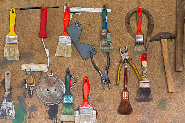 Hanging Tools on Wood Panel - Herramientas Colgadas Various tools used hanging and exposed on wooden board - Various used tools hung and exposed on wooden plate key pegboard stock pictures, royalty-free photos & images