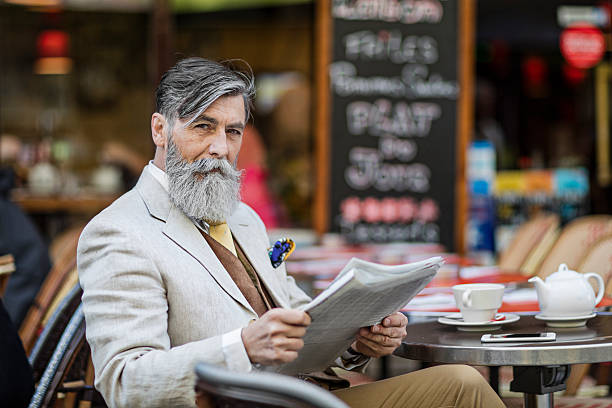 senior businessman with newspaper at street cafe - reading newspaper 30s adult imagens e fotografias de stock