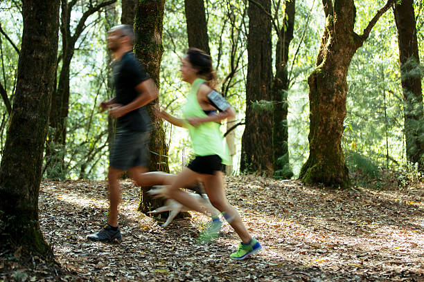 istock Latin couple running fast with dog in the forest 636242594
