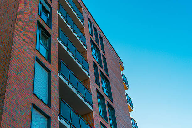 istock beautiful orange brick building with blue windows and sky 636244636