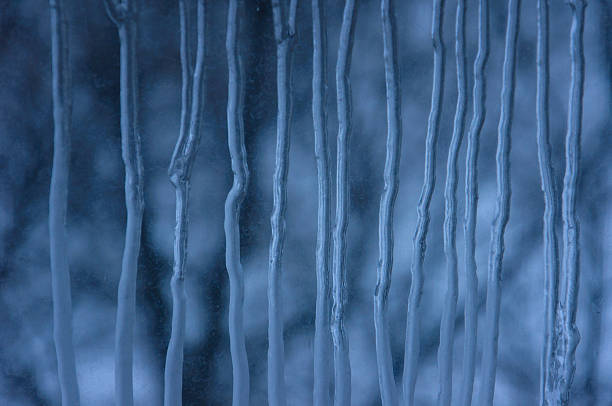 istock Frozen water drops on window glass, abstarct blue ice stripes 636245868