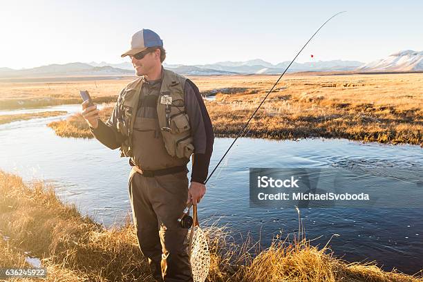 Fly Fisherman On His Cell Phone Stock Photo - Download Image Now - Fishing, Mobile Phone, Men