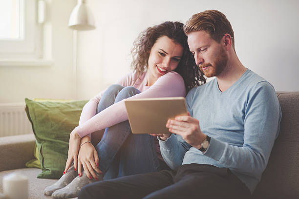 istock Happy couple surfing on tablet at home 636246792