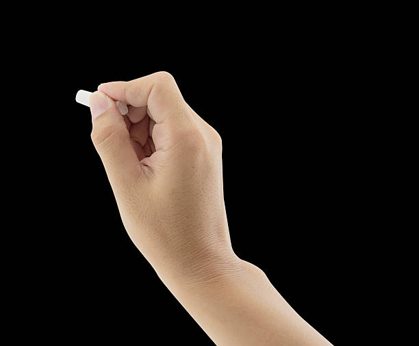 istock Hand holding white chalk and starting to write isolated 636247252