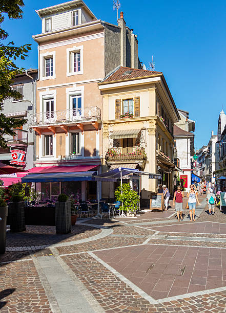 Evian-les-Bains, France. Street view with tourists walking and shops Evian-les-Bains, France - July 19, 2016: Street view in the old town, with tourists walking and shops. evian les bains stock pictures, royalty-free photos & images