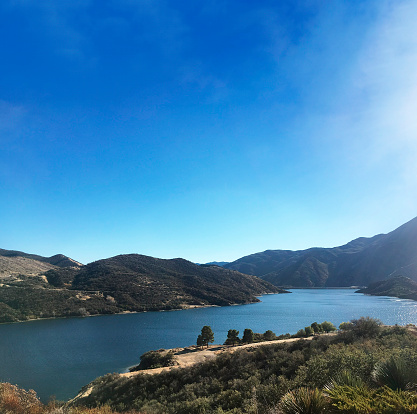 Pyramid Lake with hills on a blue sky.