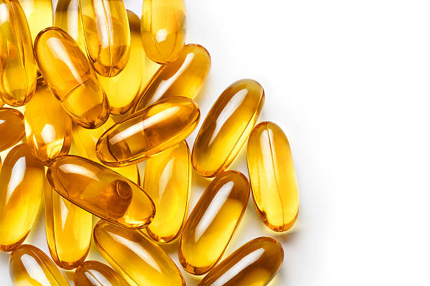 pila di capsule omega 3 su sfondo bianco. - cod liver oil fish oil capsule yellow foto e immagini stock