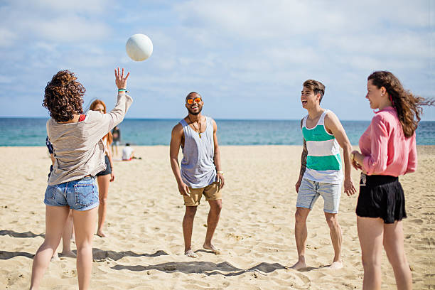 счастливый друзей веселиться на пляже - men summer passing tossing стоковые фото и изображения
