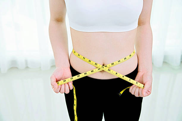 istock Young woman measuring her waist 636253520