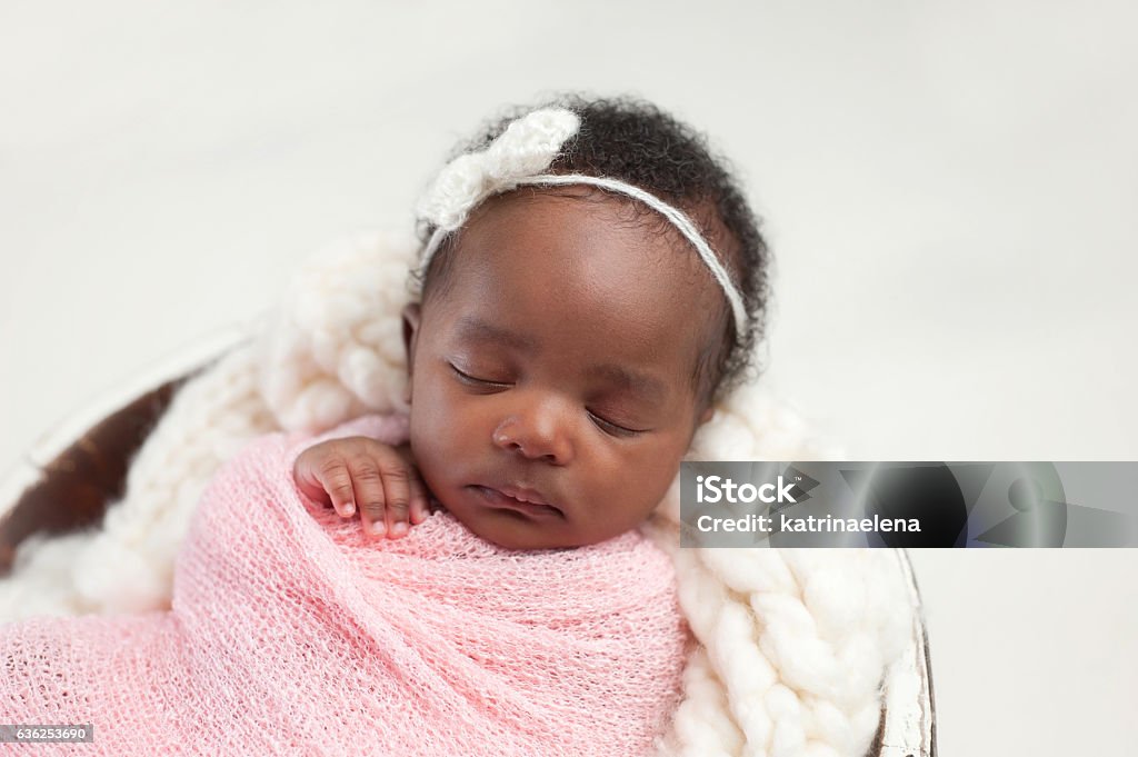 Newborn Baby Girl Sleeping in Bowl Portrait of a one month old, sleeping, newborn, baby girl. She is swaddled in pink and sleeping in a tiny bucket. Newborn Stock Photo