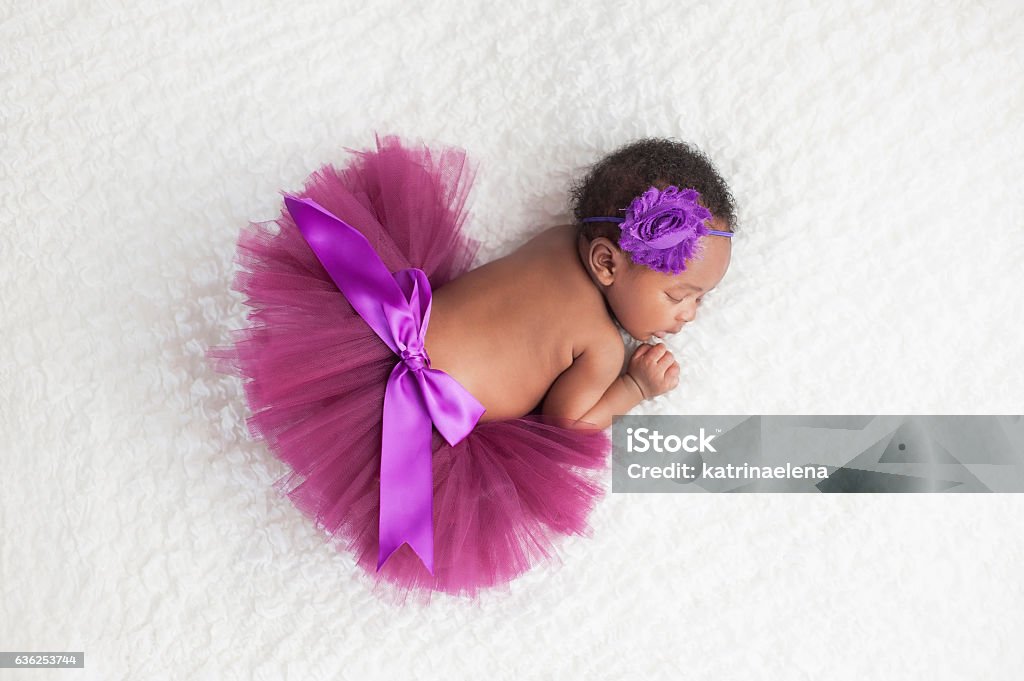 Newborn Baby Girl Wearing a Purple Tutu Portrait of a one month old, sleeping, newborn, baby girl. She is wearing a purple tutu and sleeping on a white blanket. Baby - Human Age Stock Photo