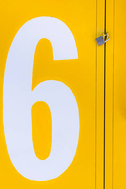 istock Yellow closed gate with padlock with a white number 6 636254602