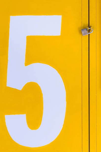 istock Yellow closed gate with padlock with a white number 5 636254734