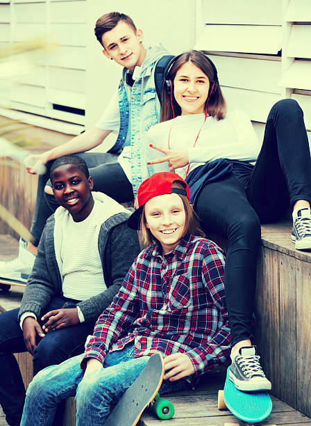 istock girl and three boys hanging out outdoors and discussing somethin 636257710