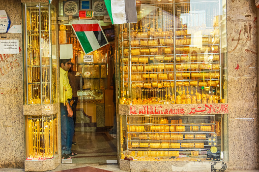 Dubai, United Arab Emirates - May 3, 2013: jewelers in a typical gold shop in Old Deira. The Grand Souk Deira is an entire neighborhood of narrow streets and dark and bottege selling spices, gold, perfumes.