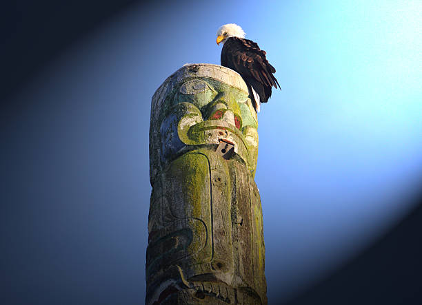 An eagle sits on top of a Native Indian's totem pole illuminated by a shaft of light