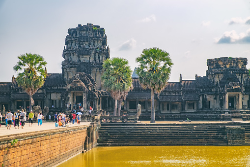 Siem Reap, Cambodia - February 1, 2016: Unidentified tourists visit to main entrance of Angkor Wat temple, Siem Reap, Cambodia. The largest religious monument in the world.
