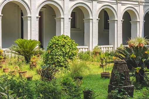 Patio with tropical plants in pots in the famous landmark - Basilica of Bom Jesus or Borea Jezuchi Bajilika. Basilica - UNESCO World Heritage Site and functioning church.
