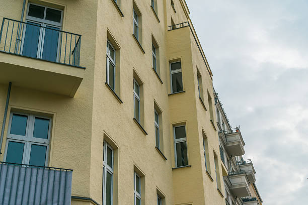 istock beautiful yellow corner house with balconies and blue windows 636262182