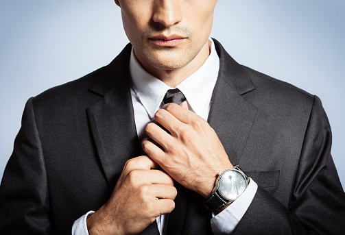 Man in the suit fixing his tie. Business and fashion concept. 