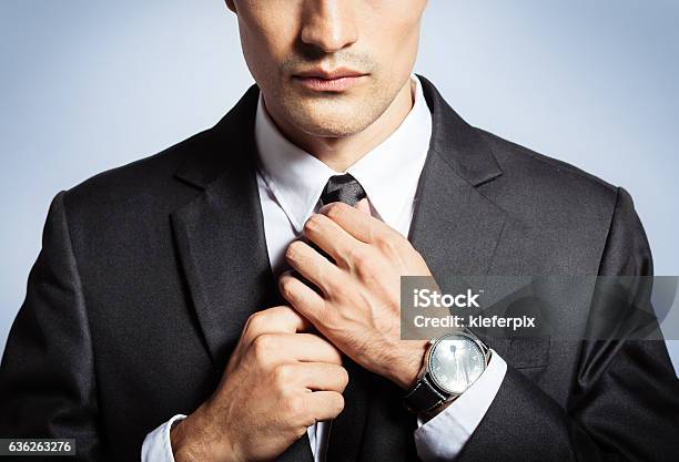 Man In The Suit Fixing His Tie Stock Photo - Download Image Now - Men, Necktie, Tying