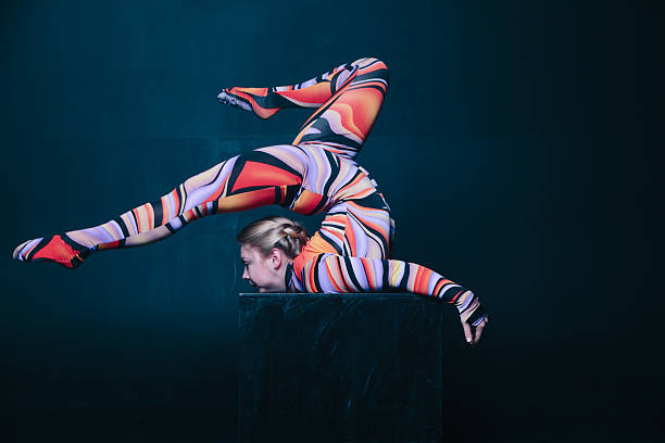 istock Young flexible blonde circus acrobat posing in studio in costume 636265450