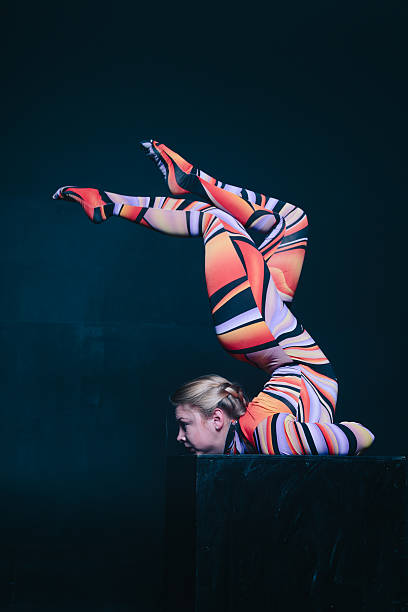 istock Young flexible blonde circus acrobat posing in studio in costume 636266446