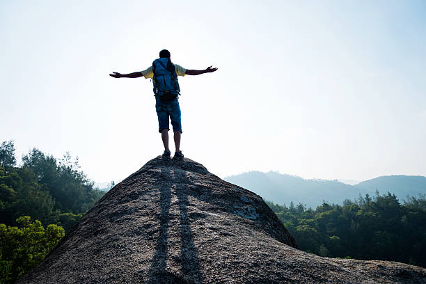 istock Man success standing at mountain peak 636269212