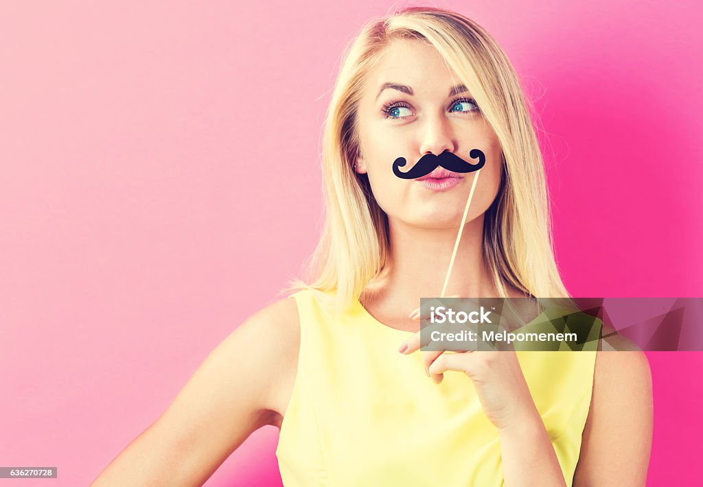 Mujer joven sosteniendo palos de papel para fiestas - Foto de stock de Bigote libre de derechos