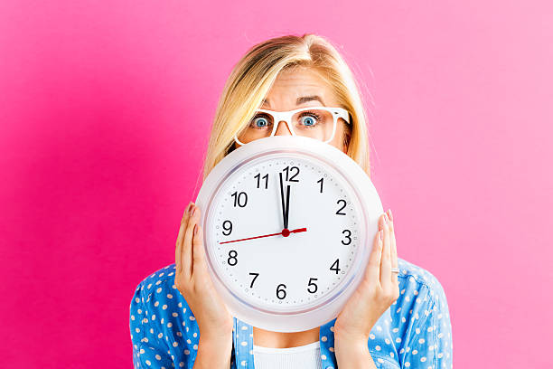 istock Woman holding clock showing nearly 12 636270738