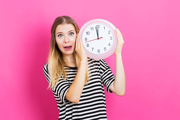 istock Woman holding clock showing nearly 12 636271054