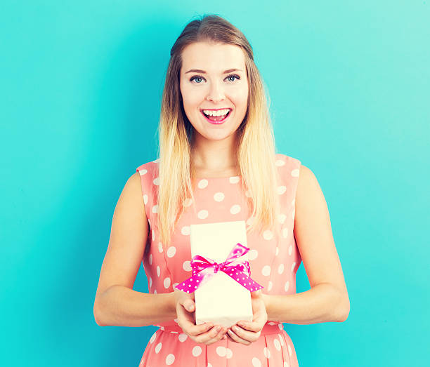 istock Happy young woman holding a gift box 636271188
