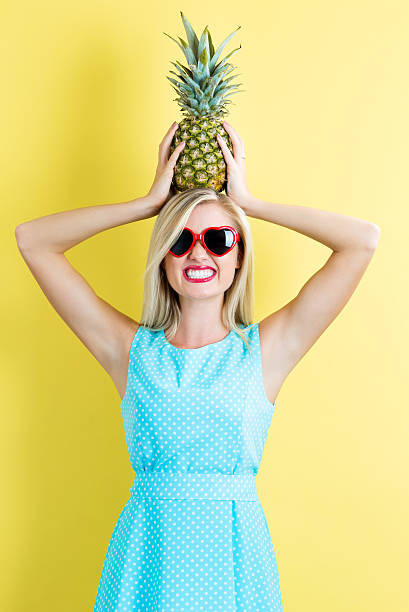 istock Happy young woman holding a pineapple 636271576