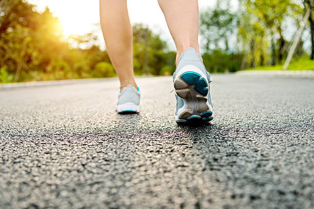 istock Woman's running shoes on asphalt road 636275276