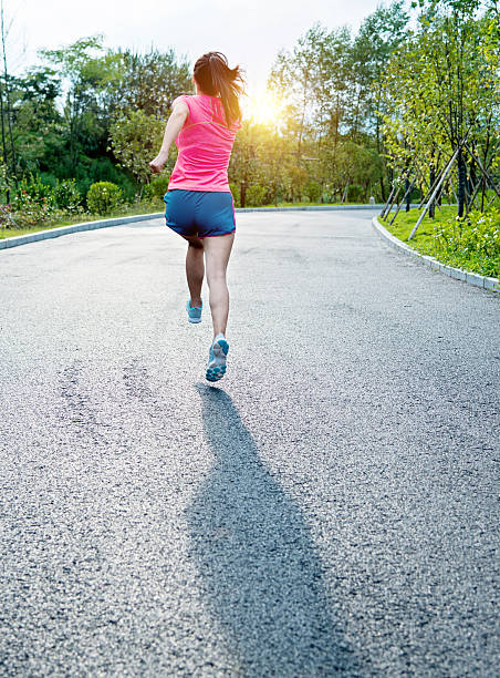 istock woman jogging in a park 636275566