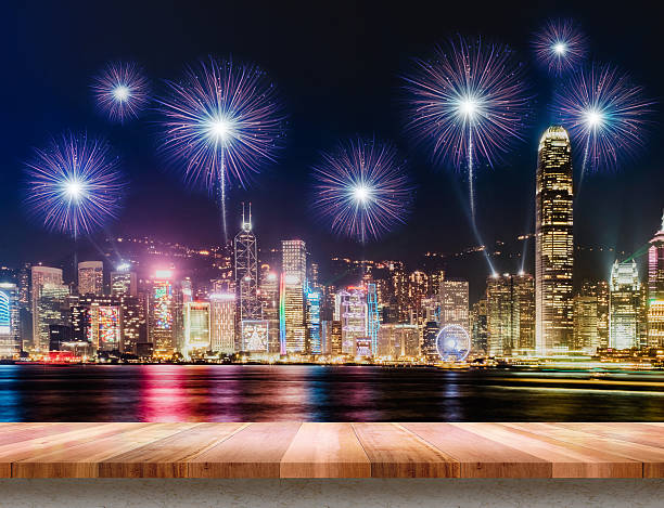 istock Empty wood plank table top with fireworks over cityscape 636277086