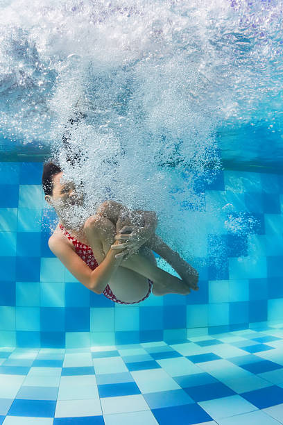 istock Girl diving underwater in swimming pool 636277926
